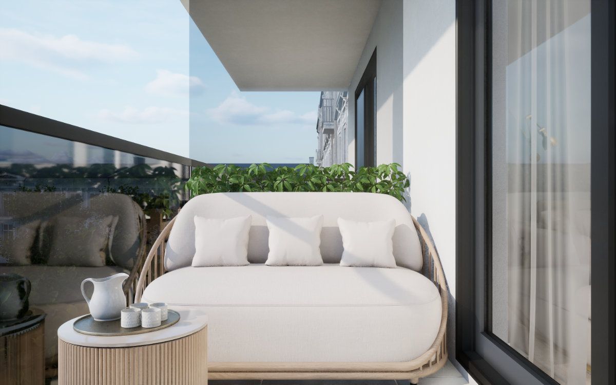 Balkon mit Tagesbett hinter der Glasbrüstung